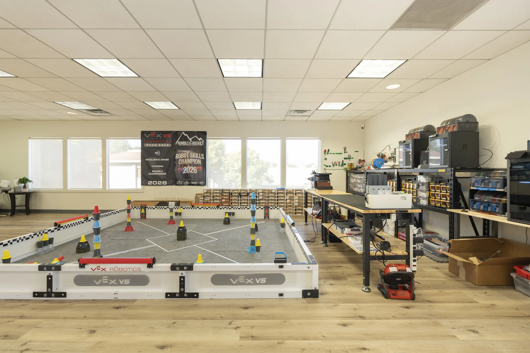 The lab's full-size VEX competition field, with workbenches along the wall.