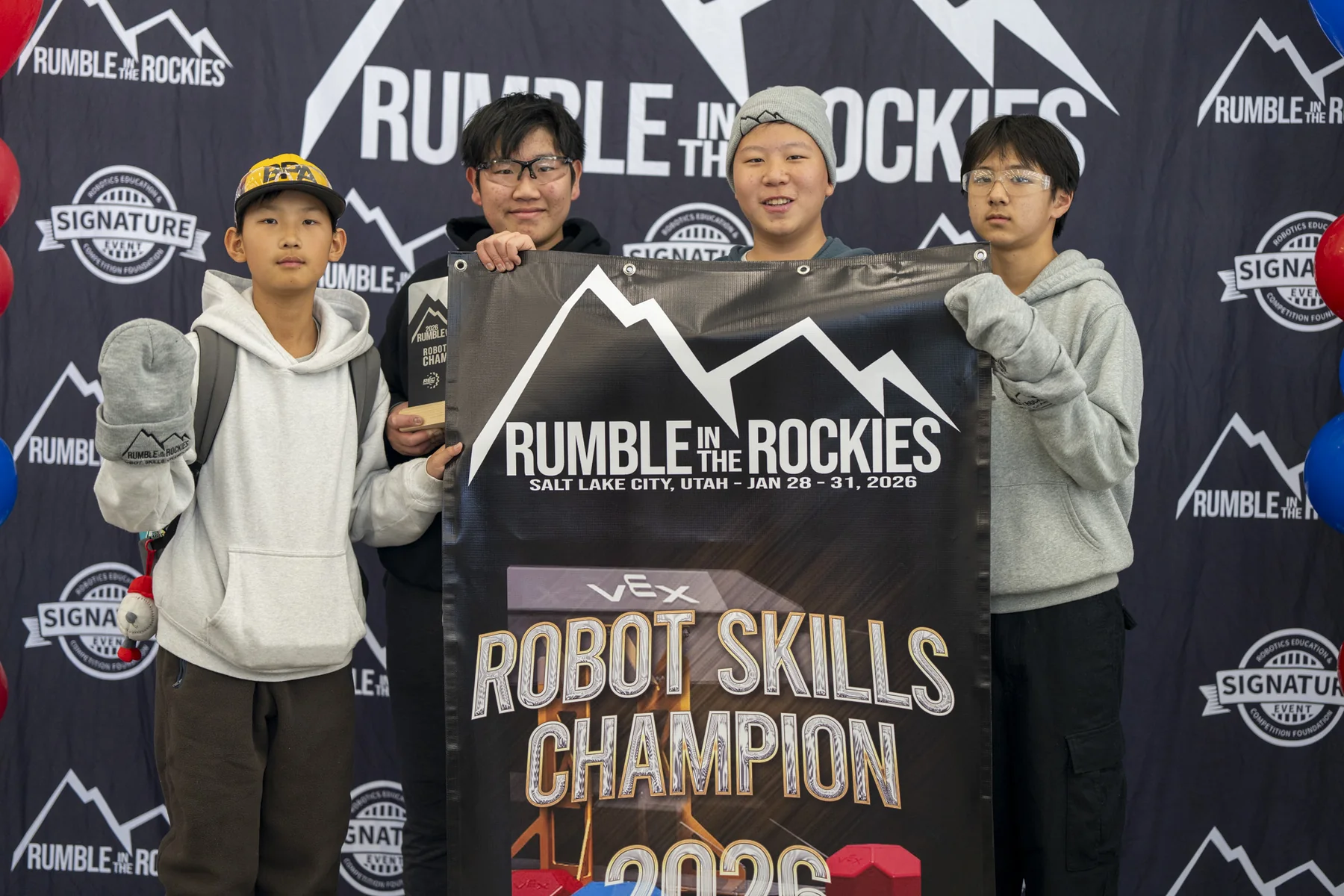 Four team members holding the Robot Skills Champion banner at the VEX Signature Event.